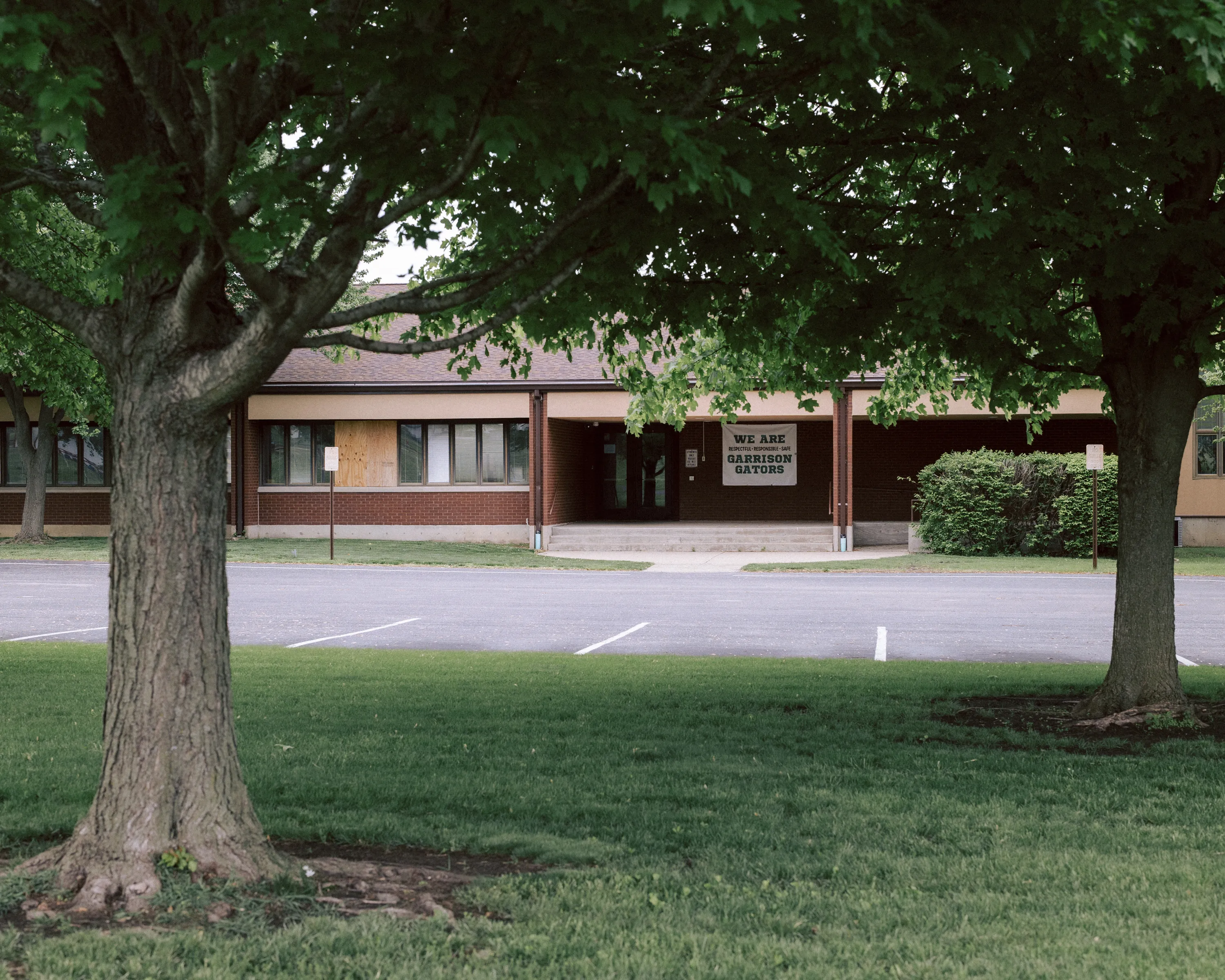 A low-slung brick building with a banner out front reading 