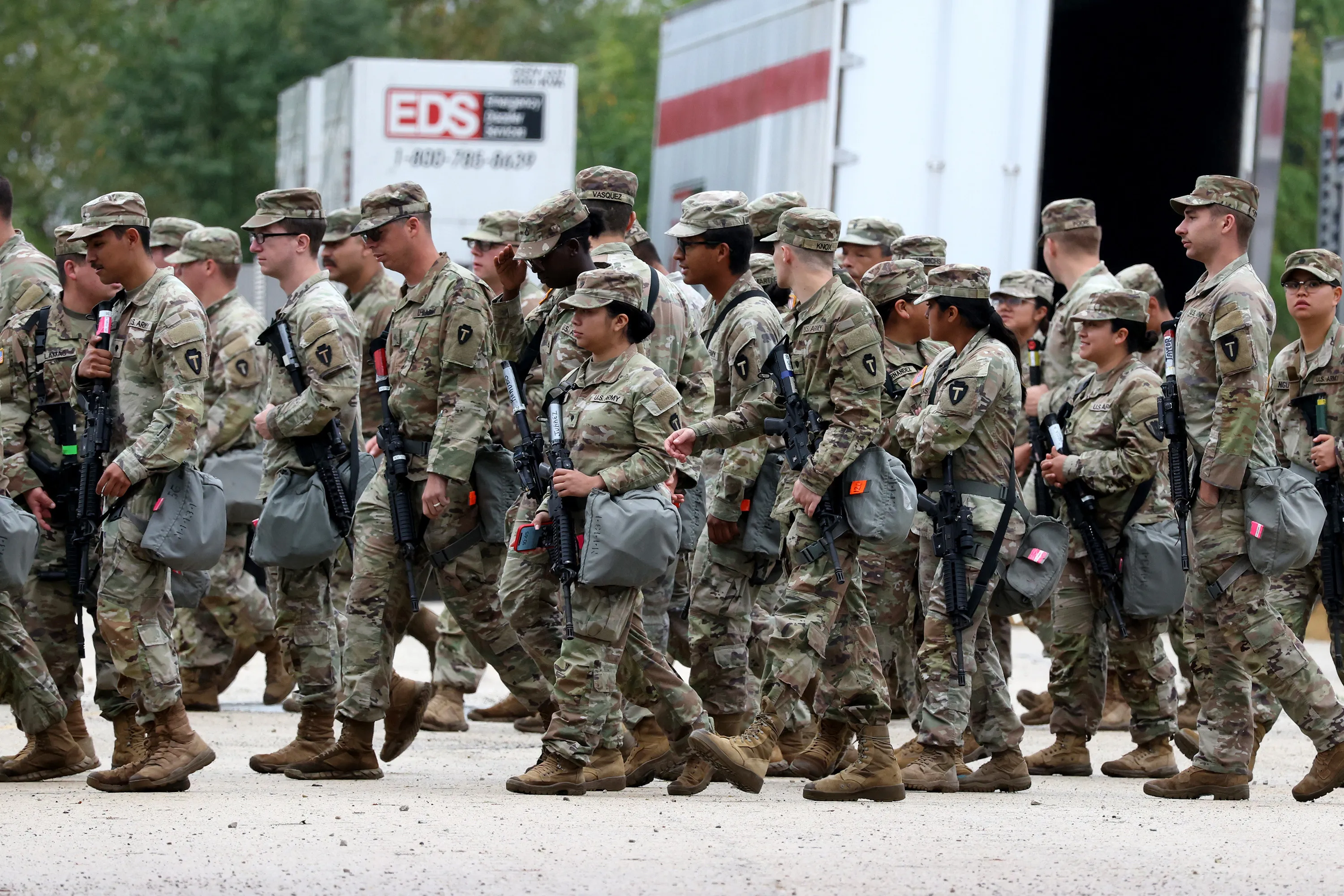 Armed guard members in camouflage fatigues.