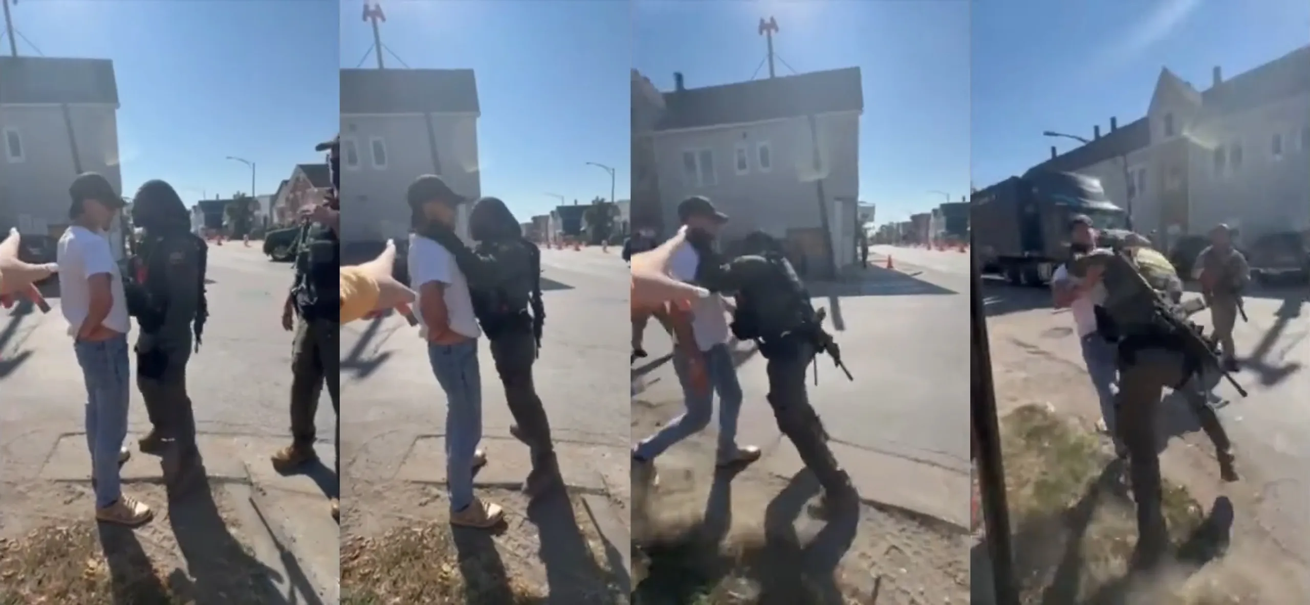 A uniformed Border Patrol officer with a large gun slung around his back has his hands around the neck of a man wearing jeans, a white T-shirt and a baseball hat in a residential neighborhood lined with houses.