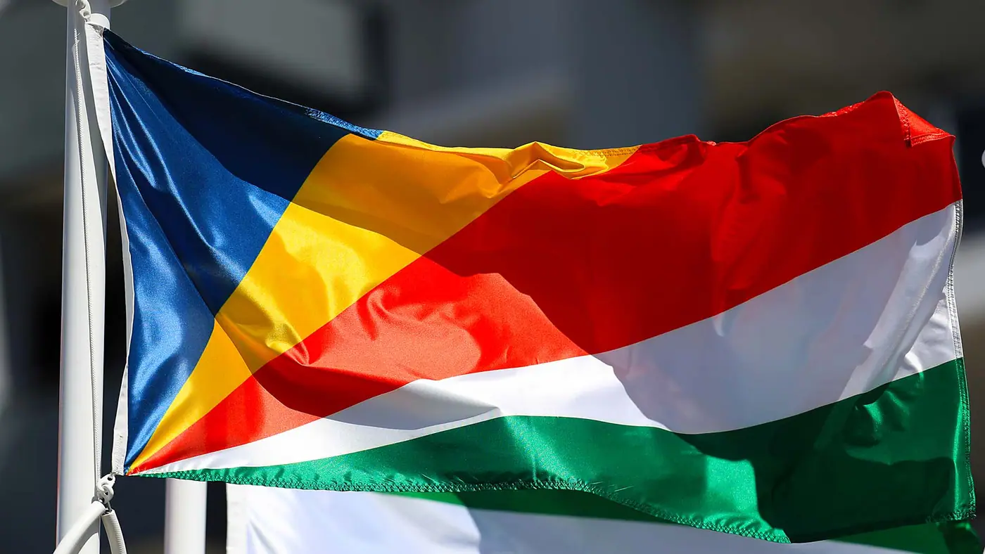 Close-up photo of blue, yellow, red, white and green flag flying in the wind.